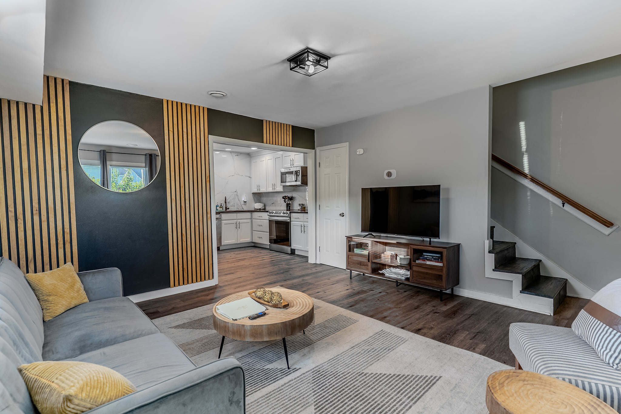 Stylish living room with smart TV, open kitchen, and chic decor