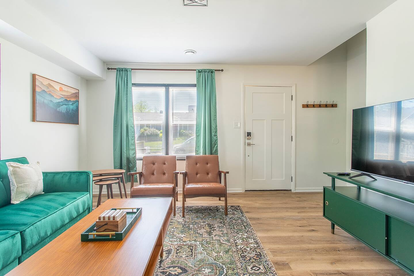 Open-concept living with stylish design, natural light, and a cozy sleeper sofa. Enjoy Roku TV, games, and books in this welcoming entry space.