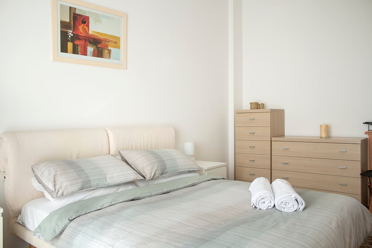 Bedroom with air conditioning, access to private balcony with sunset views and outside furniture.