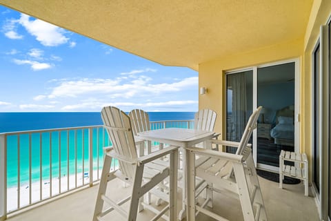 Private gulf-front balcony with high-top seating—perfect for dining with panoramic ocean views.