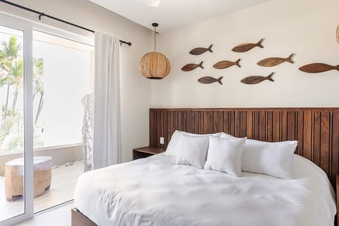 Master bedroom with King size bed, sliding doors to balcony and pool and partial ocean view