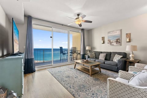 Comfortable Gulf-view living room with sofa seating and private balcony access overlooking the water.