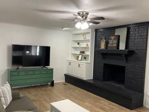Main living room has large Roku TV, fireplace (off during summer season) board games, and outdoor games for kids.