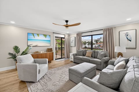 Spacious coastal living room with comfortable seating, a queen size sleeper sofa, and private balcony access.