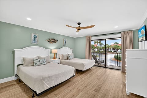 Large guest bedroom featuring two queen size beds and private balcony access.