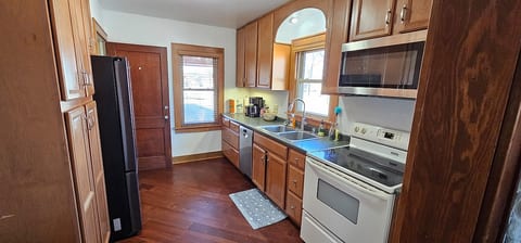 This full kitchen is stocked with essentials and ready for your stay. It features stainless steel appliances, plenty of cabinet space, and a cozy layout—perfect for morning coffee, quick meals, or cooking up something more.