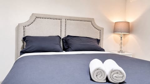 Cozy, well-styled bedroom with plush bedding and warm bedside lighting