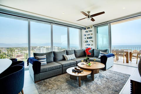 Relax in the spacious living room, where sliding glass doors on both sides open to a refreshing breeze and extend the experience to a wraparound balcony offering seamless indoor-outdoor living with views of the Pacific Ocean and surrounding mountains.