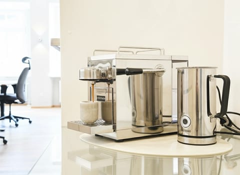 Barista-style espresso setup in a bright, modern, work-friendly space