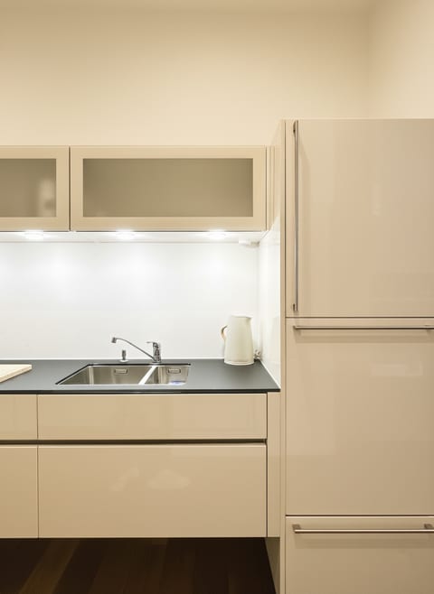Sleek compact kitchenette with lighting and integrated full-size fridge