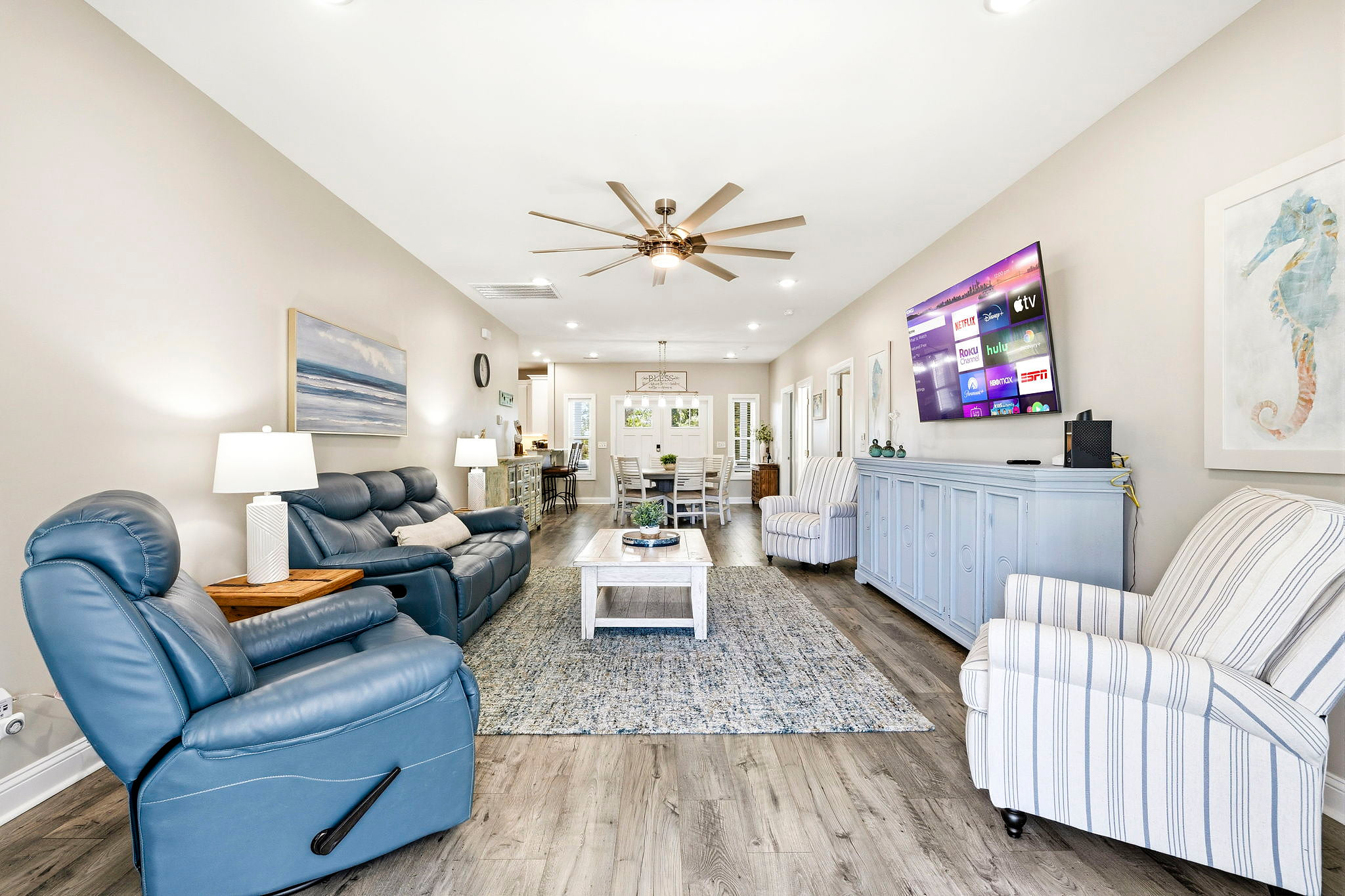 Spacious open-concept living room with plush leather sofa & recliner, 2 additional high-quality chairs, 82-in SMART TV