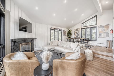 Gather, unwind, and settle into alpine comfort 🛋️🏔️. With a spacious designer sectional, swivel chairs for conversation, and a smart TV for movie nights, this light-filled living room is the heart of every stay ✨