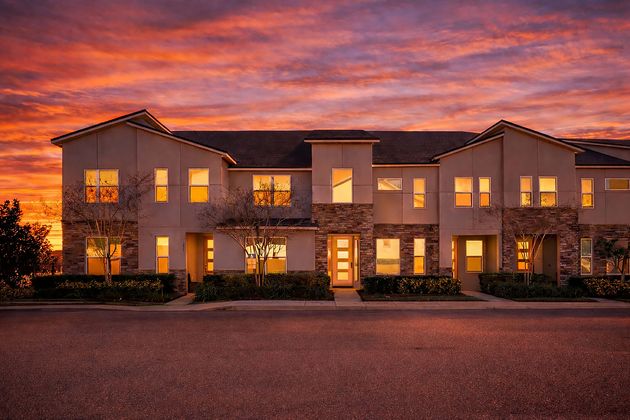 Modern townhome exterior with warm glow and sunset curb appeal