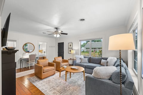 Bright living room with smart TV, curated designer interiors, and a dedicated desk/workspace