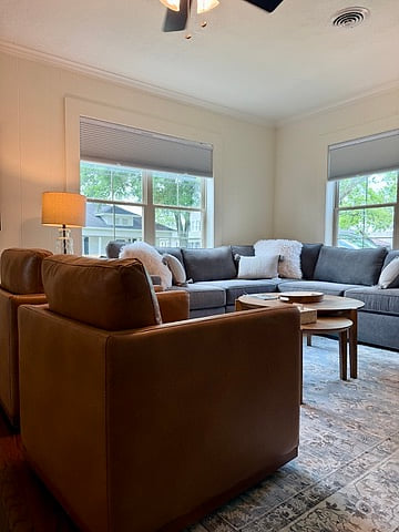 Bright lounge with plush sectional, leather chairs & big windows