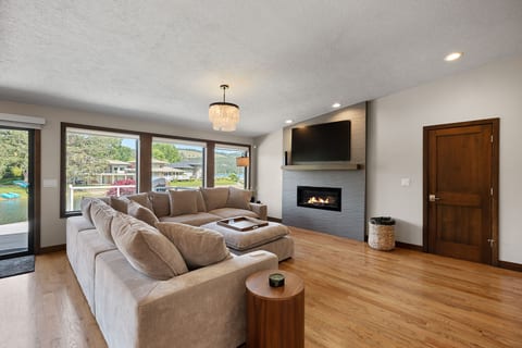 Bright modern living room with oversized sectional, fireplace, and TV