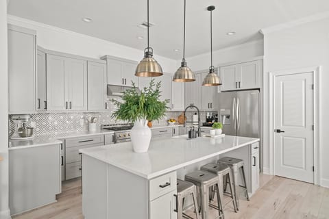 Bright modern kitchen with oversized island, seating, and stainless appliances