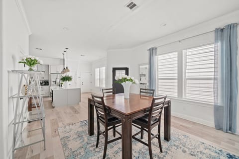 Bright open dining area with modern kitchen and abundant natural light
