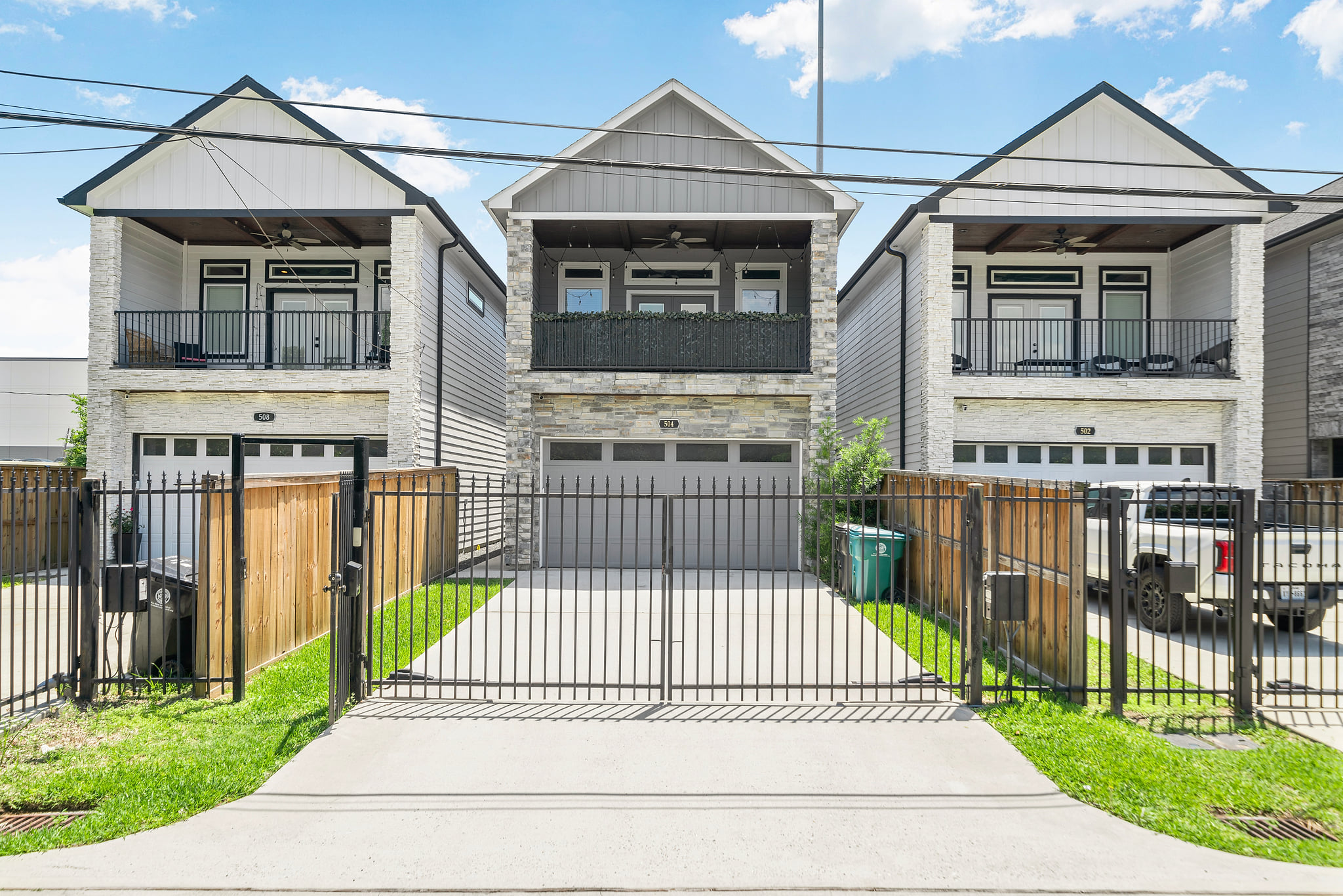 Modern two-story home with gated driveway, garage, and private balcony