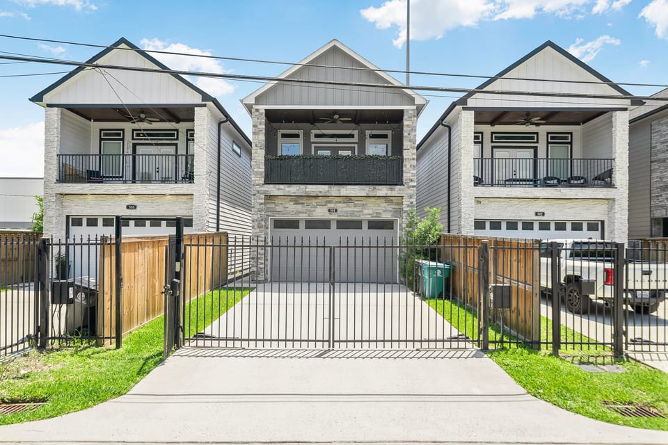 Modern two-story home with gated driveway, garage, and private balcony