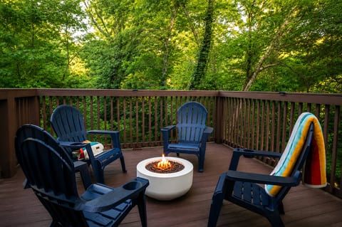 Private wooded deck with Adirondack chairs and a cozy fire pit