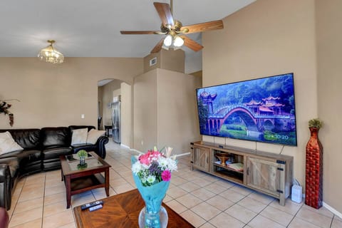 Bright living room with big smart TV, leather sectional & vaulted ceilings