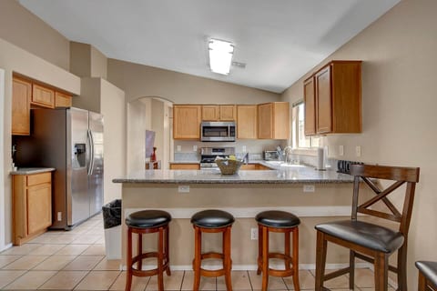 Spacious kitchen with granite bar, 4 stools & stainless appliances