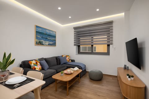 Bright modern lounge with cozy sectional, dining nook, and wall-mounted TV
