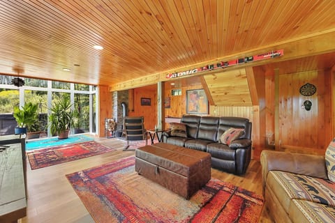 The walk-out basement has a large screen smart TV, shuffleboard, magnetic dart board, pull-out couch, an ottoman that folds out into a single bed, a woodstove, and it all leads out to the hot tub. Free firewood is just outside the door.