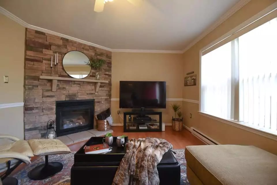 The living room features a warm and cozy gas fireplace, spacious sectional, lounger chair, DVD player and streaming TV.