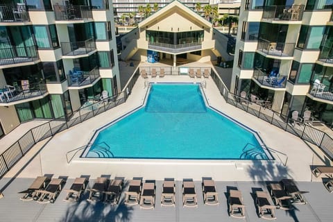 Relax by the sparkling beachfront resort pool surrounded by lounge chairs and tropical vibes.