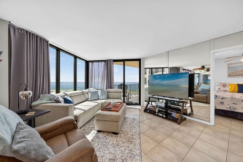 Relax in the comfortable living room with stunning Gulf views and balcony access.