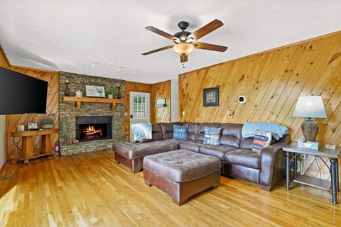 The Hearth Room — electric fireplace, Smart TV, and floor-to-ceiling views of the North Georgia mountains. This is where your family unwinds. 🛋️🔥