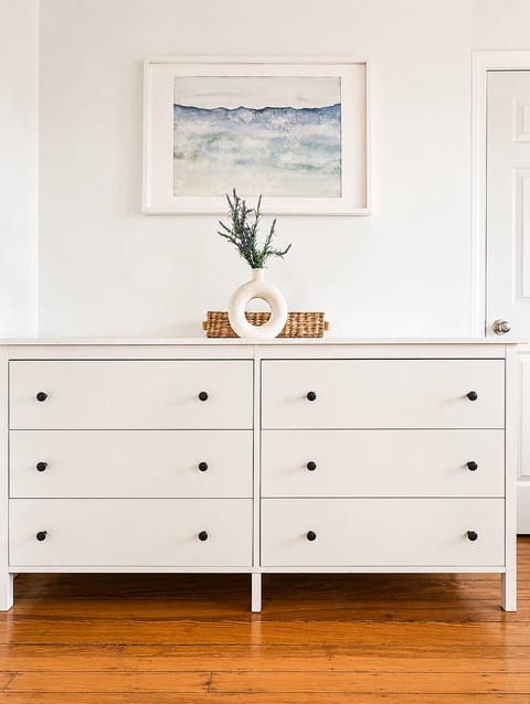 Bright minimalist dresser with stylish decor and warm hardwood floors