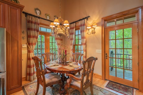Enjoy meals together in the warm and inviting dining area, perfectly positioned within the open-concept living space beneath beautiful vaulted ceilings.
