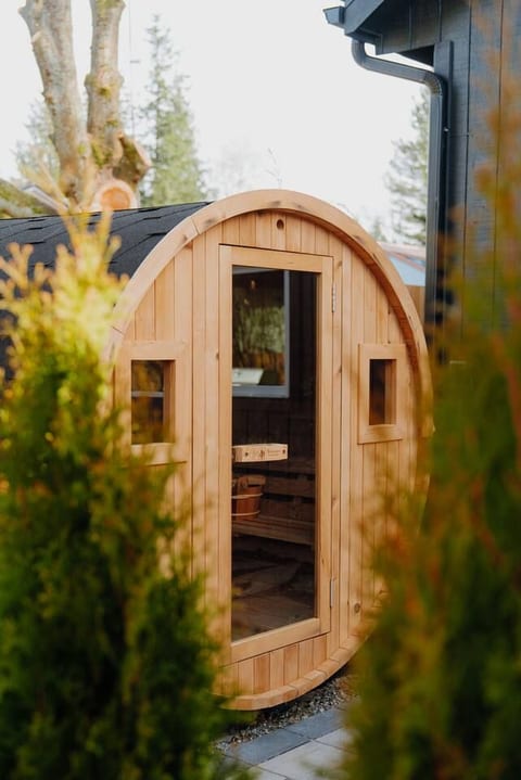 Redwood Outdoors barrel sauna tucked among the evergreens