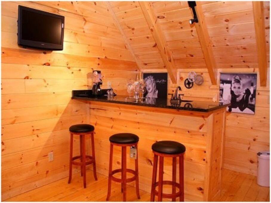 Wet Bar with a Refrigerator and Faucet in addition to a TV