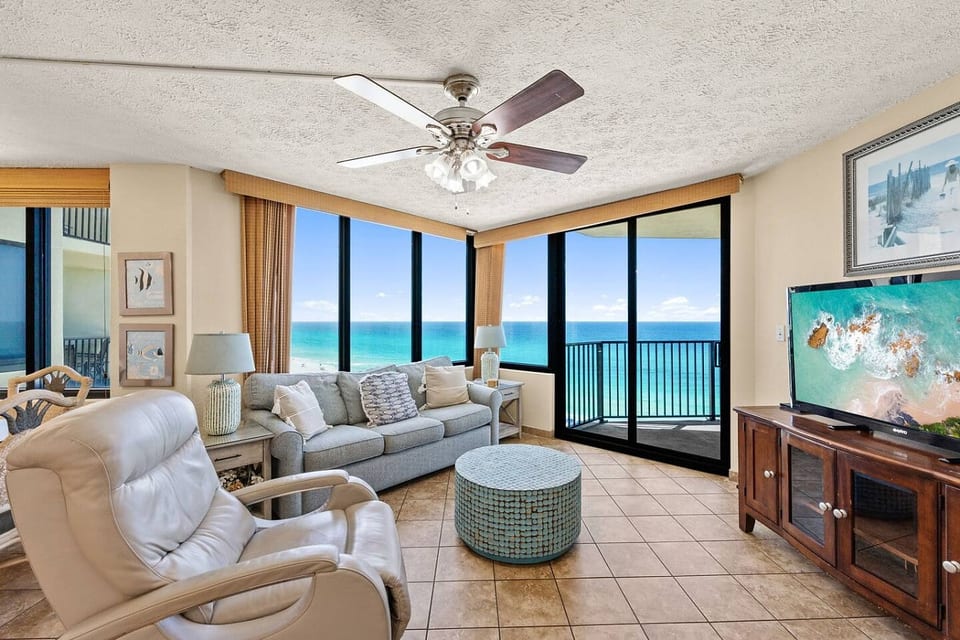 Comfortable beachfront living room with panoramic Gulf views and direct balcony access.