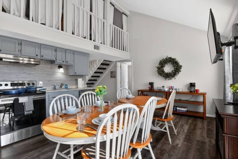 Dining area with 6-person table plus extra seating, deluxe coffee station, and fully stocked kitchen with oven, microwave, blender, toaster, and essentials. Cozy fireplace and Smart TV, with direct access to Deck #2 for outdoor relaxation.