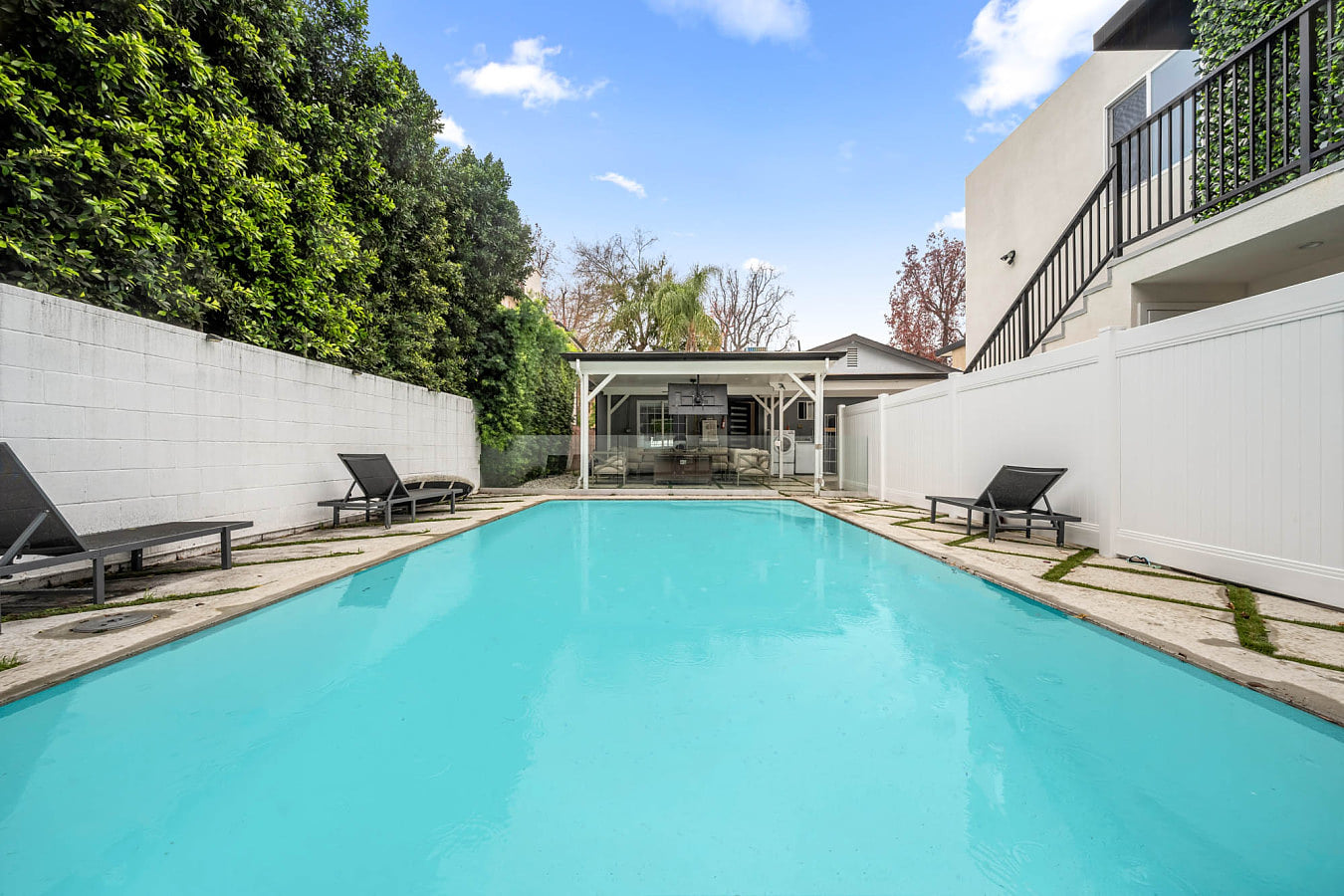 Pool area with a charming side patio — perfect for lounging