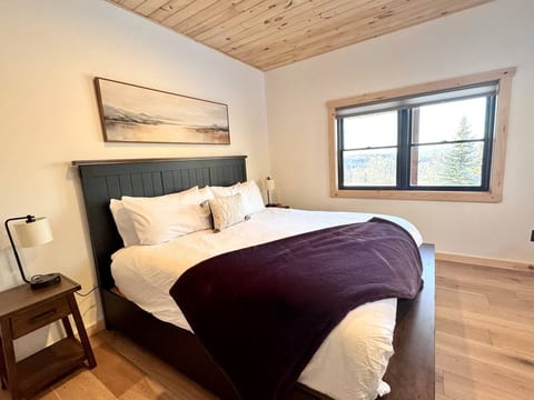 The second king bedroom is on the lower level and includes a king bed, views, ensuite to shared full bath with oversized shower and double vanity. 