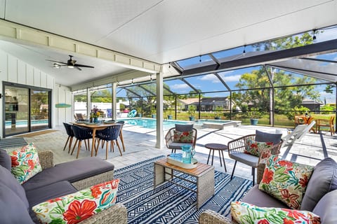 Relax and unwind in the covered seating area next to the pool, with comfortable outdoor furniture and a dining table