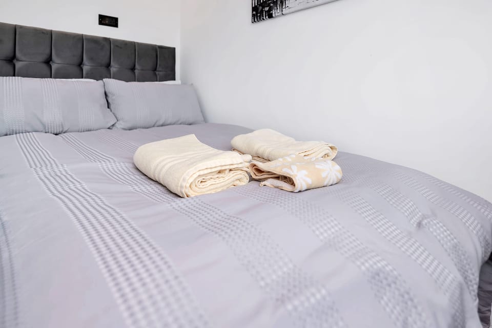 Cozy bedroom with plush headboard and fresh linens ready for you