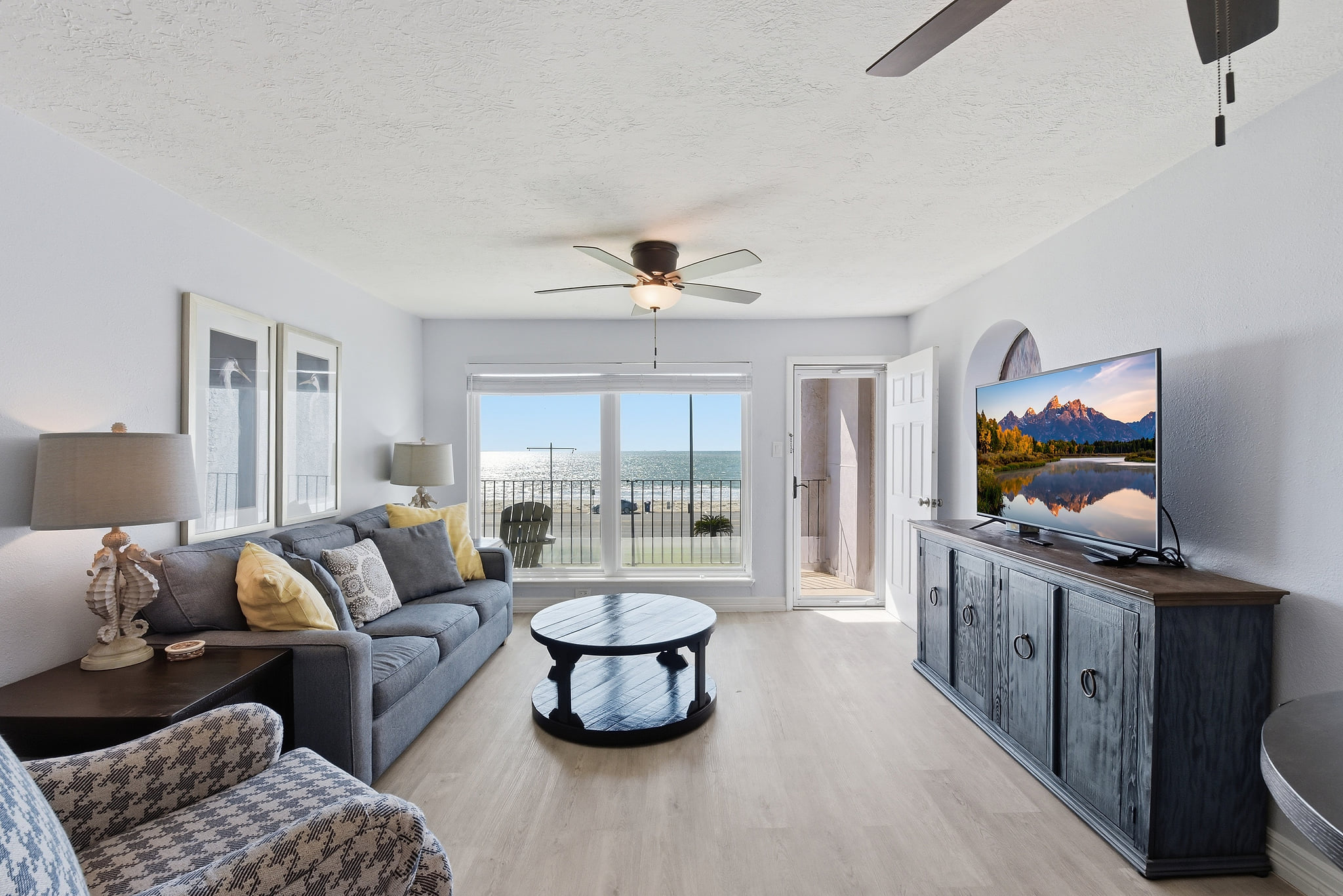 Bright oceanfront living room with balcony and coastal decor