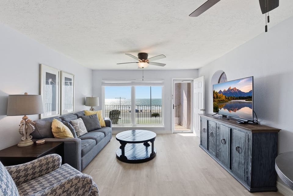 Bright oceanfront living room with balcony and coastal decor