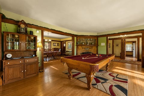 Classic game room with pool table, fireplace, and open dining area