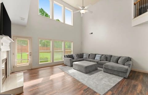 Bright double-height living room with oversized windows and spacious sectional