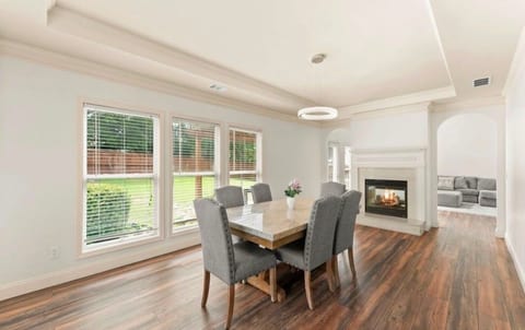 Bright dining space with large windows, fireplace, and elegant open layout