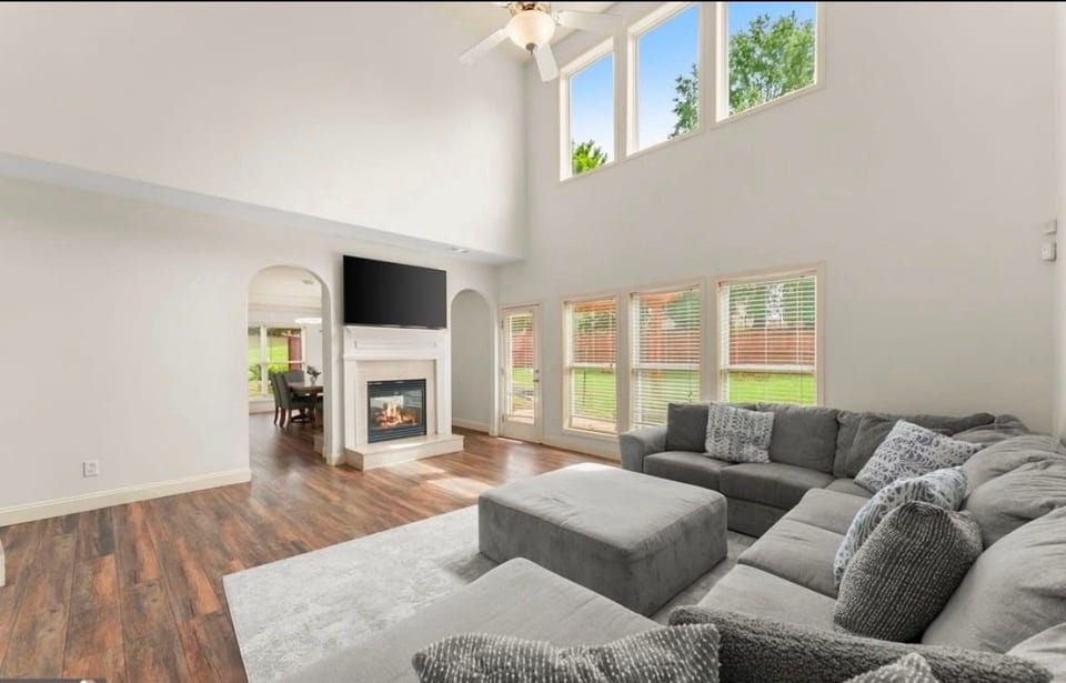 Bright vaulted living room with fireplace, big windows, and spacious seating