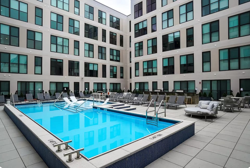 Resort-style courtyard pool with loungers and modern city vibes